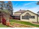 Expansive backyard with a covered patio, manicured lawn, established garden beds, and lush landscaping at 7217 S Zephyr Way, Littleton, CO 80128