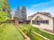 Spacious backyard with a covered patio, lush lawn, putting green, established garden beds and mature trees for outdoor enjoyment at 7217 S Zephyr Way, Littleton, CO 80128