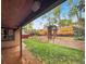 Well-maintained backyard with a covered patio, manicured lawn, garden beds, wooden fence and arbor for outdoor enjoyment at 7217 S Zephyr Way, Littleton, CO 80128
