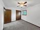 This carpeted bedroom features a window with wood trim and two wood doors at 7217 S Zephyr Way, Littleton, CO 80128