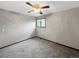 This carpeted bedroom features a ceiling fan, window with wood trim, and neutral walls at 7217 S Zephyr Way, Littleton, CO 80128