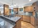 Kitchen view featuring wooden cabinetry, granite counter tops, a stainless steel stove and appliances at 7217 S Zephyr Way, Littleton, CO 80128