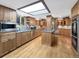 Spacious kitchen with a skylight, wood cabinets, stainless appliances, and granite countertops at 7217 S Zephyr Way, Littleton, CO 80128