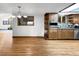 Open kitchen view featuring hardwood floors, wood cabinetry, a breakfast bar, and stainless appliances at 7217 S Zephyr Way, Littleton, CO 80128