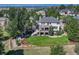 Aerial view shows a home with backyard, patio, deck, lush landscaping, and a private setting surrounded by trees at 5275 Pinyon Jay Rd, Parker, CO 80134