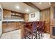 Charming bar area includes custom wood cabinetry, shelving, countertop seating, and recessed lighting at 5275 Pinyon Jay Rd, Parker, CO 80134