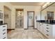 Bright bathroom boasts tiled floors, a dual sink vanity with dark countertop, and glass enclosed shower at 5275 Pinyon Jay Rd, Parker, CO 80134