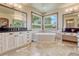 Bright bathroom featuring dual sinks, a large soaking tub, and large windows at 5275 Pinyon Jay Rd, Parker, CO 80134