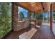 Spacious covered deck featuring a built-in grill, stone pillars, and wood ceiling for stylish outdoor living at 5275 Pinyon Jay Rd, Parker, CO 80134