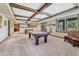 Expansive game room featuring a pool table, exposed wood beams, and large windows with scenic views at 5275 Pinyon Jay Rd, Parker, CO 80134