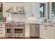 Modern kitchen features stainless steel Wolf oven and range, custom cabinetry, and stone tile backsplash at 5275 Pinyon Jay Rd, Parker, CO 80134