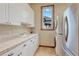 Well-appointed laundry room featuring ample counter space, cabinets, and modern appliances at 5275 Pinyon Jay Rd, Parker, CO 80134