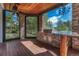 Covered outdoor kitchen with stone accents, built-in grill, and views of the surrounding wooded landscape at 5275 Pinyon Jay Rd, Parker, CO 80134