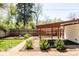 Spacious backyard with garden beds, gravel paths, and a covered patio area at 650 Kearney St, Denver, CO 80220