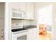 Kitchen with white cabinets, granite countertops, and a white range with microwave above at 650 Kearney St, Denver, CO 80220