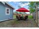 Backyard patio seating with a red umbrella for shade, perfect for outdoor dining at 134 S Quitman St, Denver, CO 80219