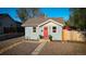 Charming single-story home featuring a red front door, gravel landscaping, and flowering planters, perfect for curb appeal at 134 S Quitman St, Denver, CO 80219