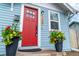 Inviting home entrance with a vibrant red door, lovely potted flowers, and charming exterior details at 134 S Quitman St, Denver, CO 80219
