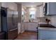 Bright kitchen featuring stainless steel appliances, white cabinets, a subway tile backsplash, and wood-look floors at 134 S Quitman St, Denver, CO 80219