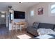 Inviting living area with modern furnishings, a wall-mounted TV, and an adjacent dining space at 134 S Quitman St, Denver, CO 80219