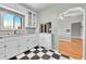 Classic kitchen features white cabinetry, black and white flooring, and lots of light at 3818 W 25Th Ave, Denver, CO 80211