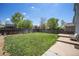 Large backyard with a grassy lawn, wooden fence, and a patio, great for entertaining at 1232 Bluebird St, Brighton, CO 80601