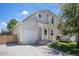 Charming two-story home with a well-maintained front yard, driveway, and attached one-car garage on a sunny day at 1232 Bluebird St, Brighton, CO 80601