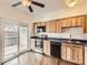 Functional kitchen with wooden cabinets, sliding doors, stainless appliances, and natural light at 13645 E Yale Ave # C, Aurora, CO 80014