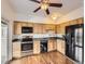 Well-lit kitchen features wooden cabinets, stainless steel appliances and hardwood floors at 13645 E Yale Ave # C, Aurora, CO 80014