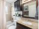 Well-lit bathroom with a granite vanity, stylish mirror, and shower-tub combination at 6513 Gray St, Arvada, CO 80003
