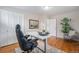 Bright home office with hardwood floors, a large desk, comfortable chair, and natural light at 6513 Gray St, Arvada, CO 80003