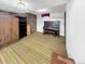 Basement rec room features a piano, paneled walls and a striped floor at 1941 E 119Th Pl, Northglenn, CO 80233