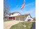 Side view of a two-story home with a spacious two-car garage, American flag, and nice yard at 1941 E 119Th Pl, Northglenn, CO 80233