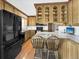 Traditional kitchen with wooden cabinets, modern appliances, and a breakfast bar with seating at 1941 E 119Th Pl, Northglenn, CO 80233