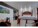 Main bedroom with tiled floor, wooden canopy bed, and a closet area at 1150 Madge Gulch Rd, Sedalia, CO 80135