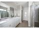 Modern bathroom featuring double sinks, a large mirror, and a glass-enclosed shower at 10786 Bear Cub Dr, Broomfield, CO 80021