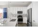 Well-lit white kitchen features stainless steel appliances and sleek quartz counters for efficient cooking at 10786 Bear Cub Dr, Broomfield, CO 80021