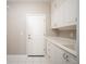 Bright laundry room with white cabinetry, ample counter space, and tile flooring at 10786 Bear Cub Dr, Broomfield, CO 80021