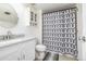 Clean bathroom with a granite countertop vanity, cabinet storage, and stylish patterned shower curtain at 4899 S Dudley St # 18A, Littleton, CO 80123