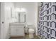 Well-lit bathroom featuring modern fixtures, granite countertop, and a shower with patterned curtain at 4899 S Dudley St # 18A, Littleton, CO 80123