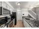 Kitchen with tile floors, white cabinets, granite counters, and black appliances at 4899 S Dudley St # 18A, Littleton, CO 80123