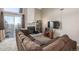 A naturally lit living room with large windows, neutral walls, and a comfortable brown sectional at 4899 S Dudley St # 18A, Littleton, CO 80123