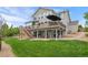 Expansive backyard with a deck, stairs, and well-manicured lawn at 688 Cinnabar Ln, Castle Rock, CO 80108