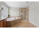 Spacious bathroom featuring a glass shower, a soaking tub, dual sinks and tile flooring at 688 Cinnabar Ln, Castle Rock, CO 80108