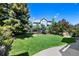 Well-maintained backyard with expansive lawn, mature trees, and partial home view at 85 Willowleaf Dr, Littleton, CO 80127