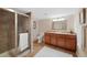 Well-lit bathroom featuring a glass-enclosed shower and vanity with ample storage space at 85 Willowleaf Dr, Littleton, CO 80127