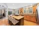 Bright eat-in kitchen featuring a large island with cooktop, wood cabinets, and stainless steel appliances at 85 Willowleaf Dr, Littleton, CO 80127