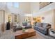 Bright living room with soaring ceilings, neutral color palette, and seamless flow into dining and kitchen at 85 Willowleaf Dr, Littleton, CO 80127