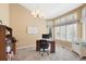 Bright home office featuring carpet, multiple windows, and a modern desk setup at 85 Willowleaf Dr, Littleton, CO 80127