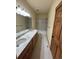 A bathroom with double sinks, modern lighting, and tiled shower and floors at 10178 Hutch Ln, Conifer, CO 80433